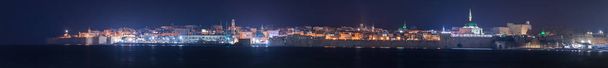 Vue panoramique nocturne depuis la mer Méditerranée sur les lanternes illuminées de la forteresse, du port et de la vieille ville d'Acre en Israël
 - Photo, image