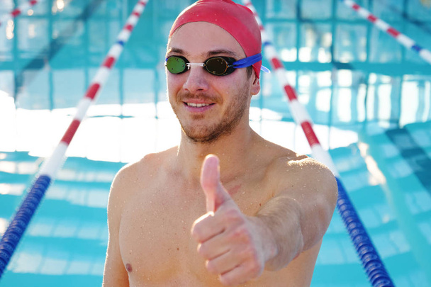 Portrait of a professional swimmer who smiles, concentrates, breathes before training to win the race by swimming in a pool. Concept of: sport, swimming pool, competition, fitness. - Foto, Imagem
