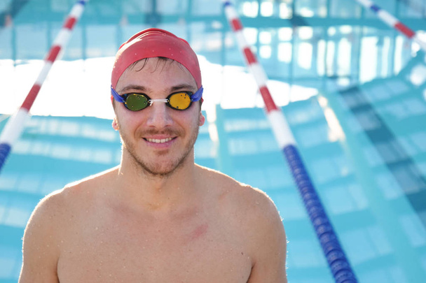 Portrait of a professional swimmer who smiles, concentrates, breathes before training to win the race by swimming in a pool. Concept of: sport, swimming pool, competition, fitness. - Foto, immagini