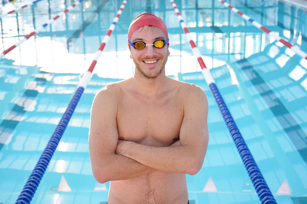 Portrait of a professional swimmer who smiles, concentrates, breathes before training to win the race by swimming in a pool. Concept of: sport, swimming pool, competition, fitness. - Photo, image