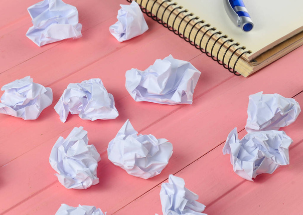 Papierkugeln, Notizbuch mit Stift auf rosa Holztisch, Businesskonzept - Foto, Bild