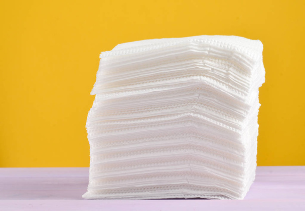 Uma pilha de guardanapos de papel branco em um backgroun pastel amarelo
 - Foto, Imagem