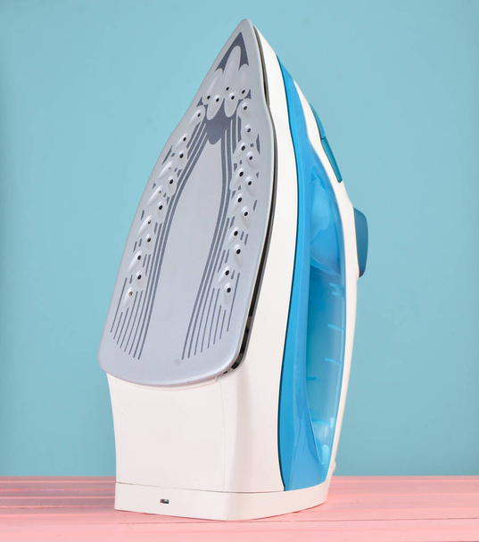 Iron for ironing on a colored pastel background, minimalist tren - Photo, Image
