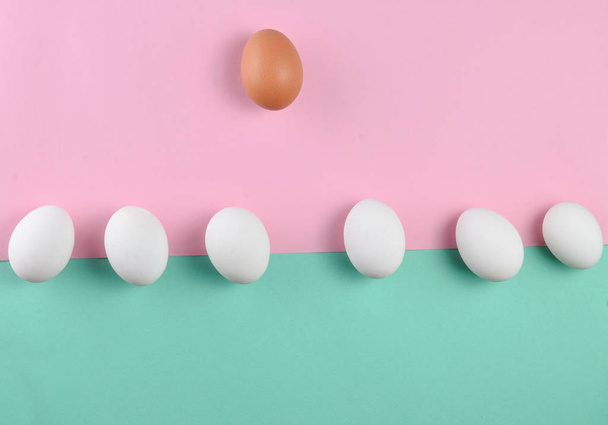 Chicken eggs on a pastel background, concept of uniqueness, minimalism, creative easter backgroun - Fotó, kép
