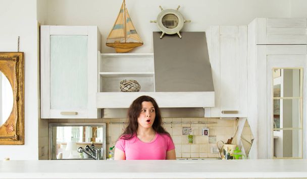 Νοικοκυρές, συγκινήσεις και ανθρώπους έννοια - έκπληκτος νεαρή γυναίκα στην κουζίνα στο σπίτι - Φωτογραφία, εικόνα