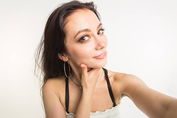Photography and people concept- Close up beautiful woman making selfie photo with funny face - Zdjęcie, obraz