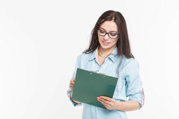 Young woman student with the green folder is standing on white background with copy space - Photo, Image