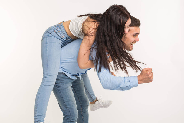 Mladý muž nesoucí na zádech jeho přítelkyně. Oni jsou blbnout - Fotografie, Obrázek