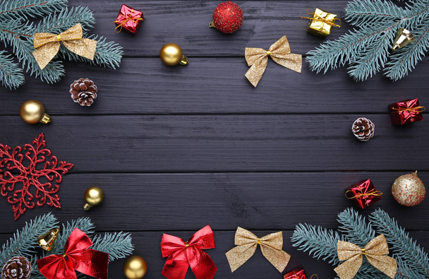 Vánoční ozdoba. jedle větev s kuličkami, dárky, borovice a luky na černém dřevěném pozadí - Fotografie, Obrázek