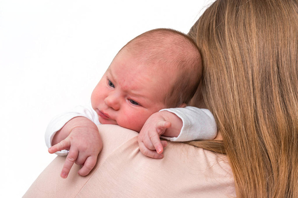 Ein Monat altes Neugeborenes liegt auf der Schulter seiner Mutter - Foto, Bild