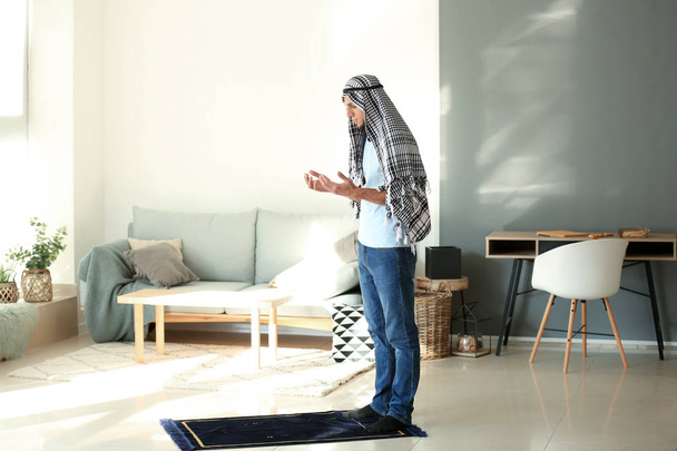 Young Muslim man praying at home - Foto, imagen