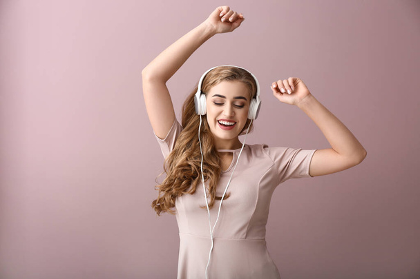 Schöne junge Frau hört Musik auf farbigem Hintergrund - Foto, Bild