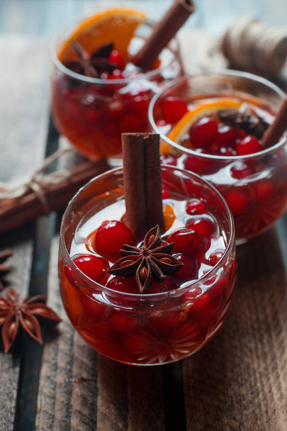 Traditional Christmas beverages with berries, lemon and cinnamon sticks  - Fotografie, Obrázek