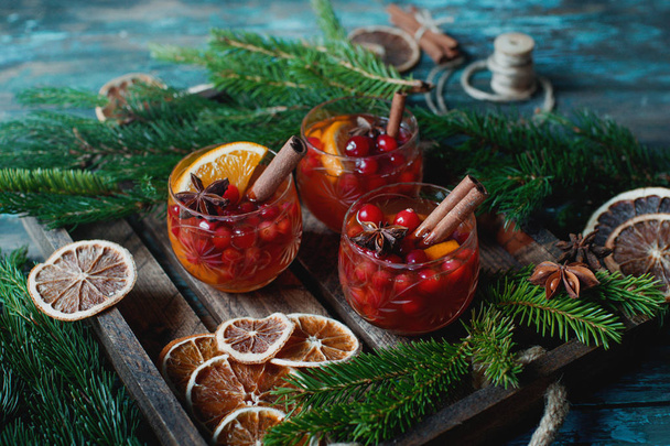 Traditional Christmas beverages with berries, lemon, cinnamon sticks and fir branches - Фото, зображення