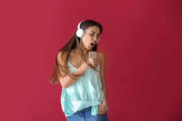 Hermosa mujer escuchando música sobre fondo de color
 - Foto, Imagen