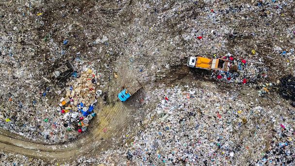Απορριμματοφόρα εκφορτώνουν σκουπίδια σε χώρο υγειονομικής ταφής πλησίον της πόλης του Γεκατερίνμπουργκ, Ρωσία, από Drone, πυροβόλησε το κεφάλι πάνω από   - Φωτογραφία, εικόνα