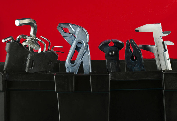 Garaje caja de herramientas de plástico con herramientas de trabajo aisladas en azul. Nippers, llave inglesa, llave hexagonal
 - Foto, Imagen