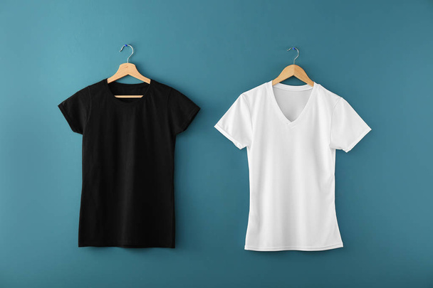 Perchas con camisetas en blanco sobre fondo de color
 - Foto, Imagen