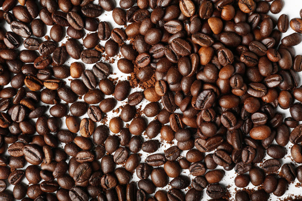 жареный кофе в зернах на белом фоне - Фото, изображение