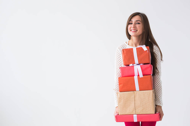 Christmas and holidays concept - woman with many gifts on white background with copy space - Photo, Image