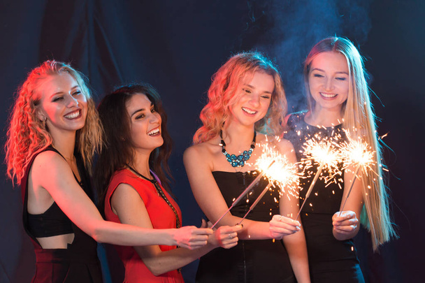 A festejar com diversão. Grupo de mulheres jovens alegres que transportam sparklers. Ano Novo, feriados e conceito de festa
. - Foto, Imagem