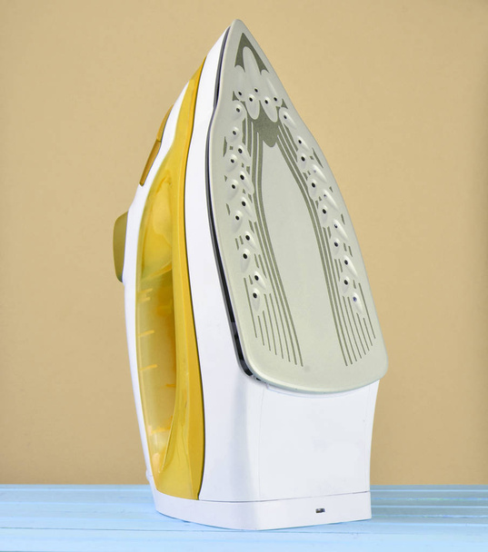 Iron for ironing on a colored pastel background, minimalist tren - Photo, Image