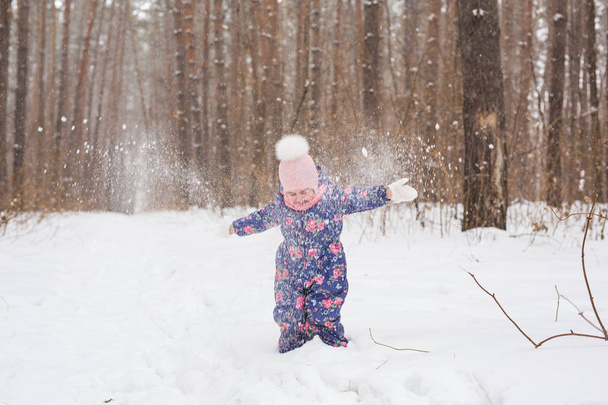 Dětství a příroda koncept - roztomilé dítě hraje v destinaci winter park - Fotografie, Obrázek