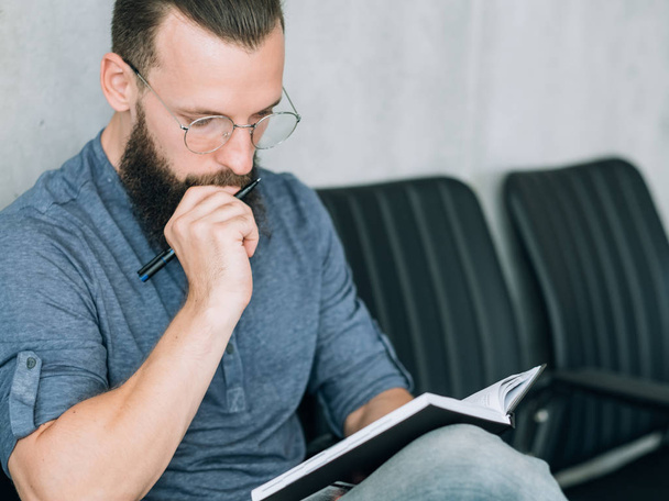 focused man reading notepad business data analysis - Фото, изображение