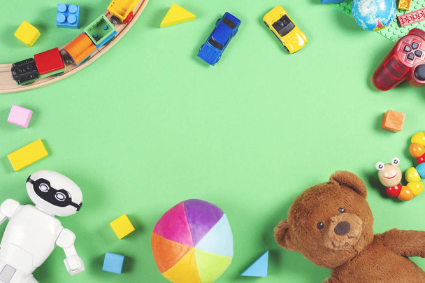 Bebek çocuklar oyuncak çerçeve oyuncak ayı, oyuncak arabalar, robot, renkli tuğlalar, pembe bir arka plan küpleri ile - Fotoğraf, Görsel