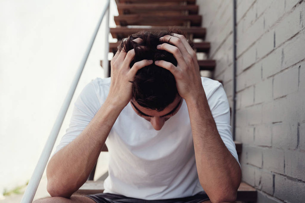 Depressed young adult man sitting alone, mental health concept - Valokuva, kuva