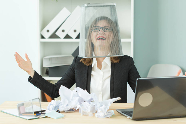 Stres, kancelář, lidé koncept - žena pracovníka se spoustou práce sedí u stolu v kanceláři dát koš na hlavu a křičet - Fotografie, Obrázek