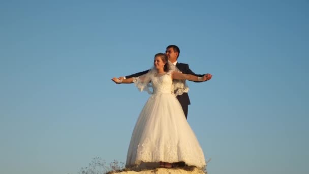 Romantic man and woman hover against blue sky and smile. Honeymoon. Romance. Relationship between man and woman - Footage, Video