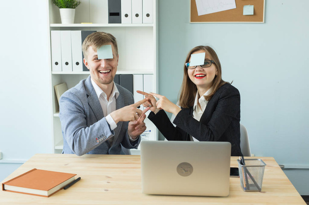 Business, break and people concept - Cheerful man and woman playing games in office while working - Foto, Imagen