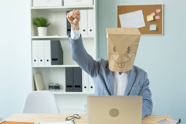 Бізнес, емоції та концепція грошей - офісний божевільний чоловік поклав на голову пакет з розфарбованим смішним обличчям. знак долара в її очах
 - Фото, зображення