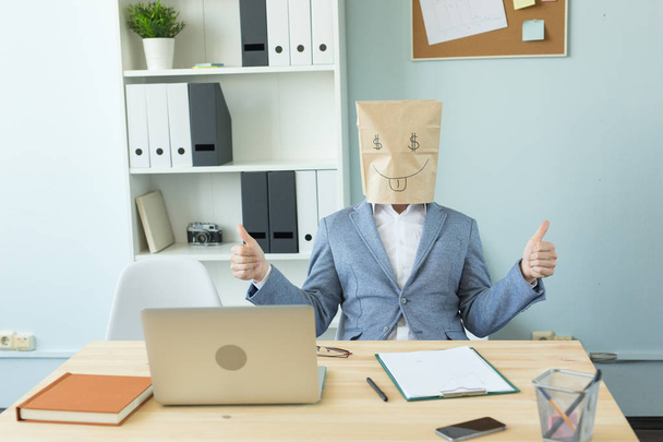 Negócios, emoções e conceito de dinheiro - homem louco escritório colocar um pacote com rosto engraçado pintado em sua cabeça. Sinal de dólar nos olhos
 - Foto, Imagem