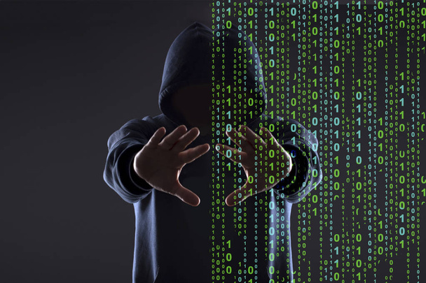 silhouet van een hacker in de kap op een zwarte achtergrond, concept realiteit versus cyberspace - Foto, afbeelding