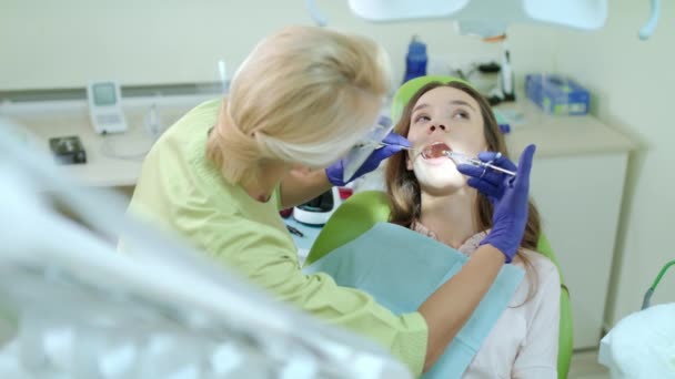 Γυναίκα οδοντίατρος χρησιμοποιώντας στόμα καθρέφτη και ιατρική σύριγγα. Θεράποντος ιατρού ασθενούς - Πλάνα, βίντεο