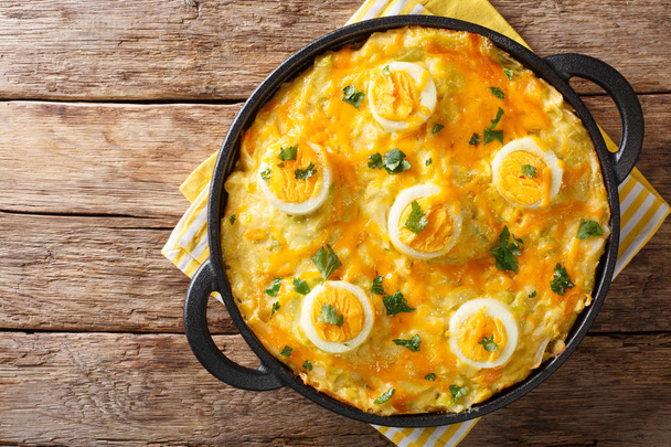 ゆでたジャガイモ、ねぎチーズ ソースとテーブルの上の卵のクローズ アップから煮込んだアングルシー卵の伝統的なウェールズ料理。abov から水平のトップ ビュー - 写真・画像