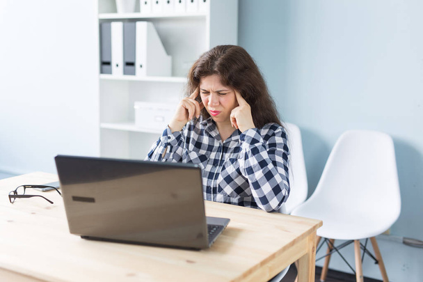 Young woman has a headache while working on laptop in office - Foto, Bild