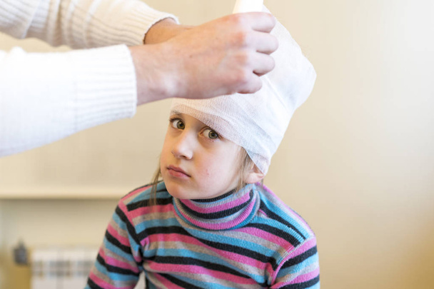 Doctor bandaged the girl's head. - Photo, Image