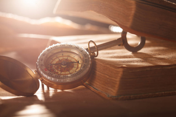 Old vintage retro compass with a book. Travel concept background. - 写真・画像