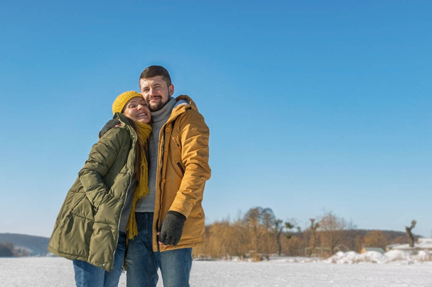 Happy young couple walking on winter sunny day. Full body, wide angle. - Fotoğraf, Görsel
