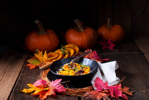 zapečená Vegetariánská dýňová s pohankovými kroupami a švestky a tymiánem v desce s podzimní listy na pozadí  - Fotografie, Obrázek