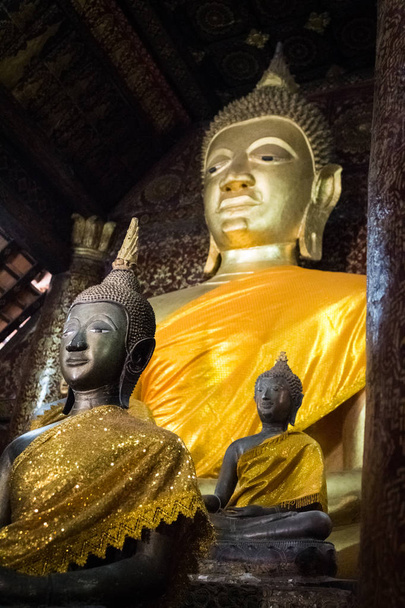 Faces de algumas das estátuas de Buda em um templo budista, Wat Xieng Thong, Luang Prabang, Laos
 - Foto, Imagem