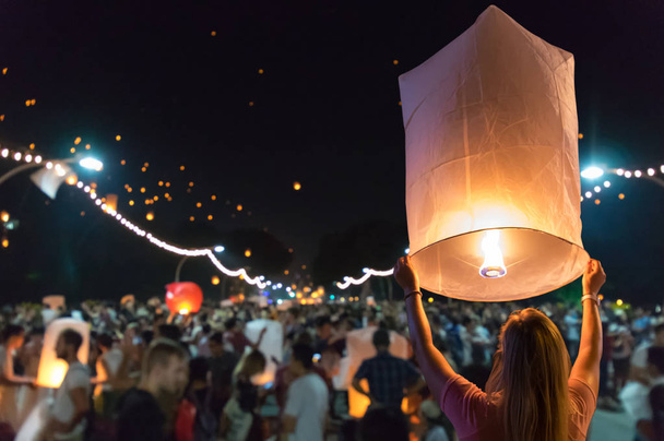 Woman releasing floating lantern in the Loy Krathong festival or floating lanterns festival in Chiang Mai, Thailand. - Photo, Image