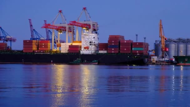 Déchargement d'un navire marchand au crépuscule de la journée dans le port maritime
 - Séquence, vidéo