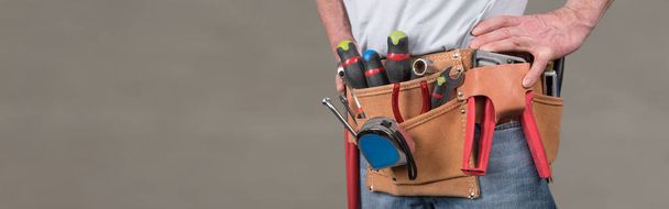 Building worker with tool belt on blurred background - Photo, Image
