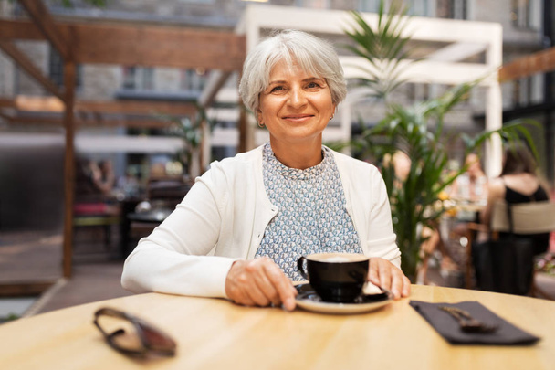 senior woman with coffee at street cafe - Foto, Imagem