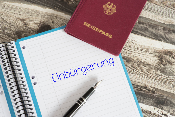 einen Reisepass und eine Broschüre mit dem Wort Einbürgerung in Deutschland - Foto, Bild