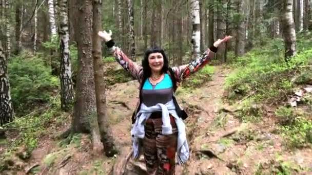 Yetişkin neşeli kadın dağlarda bir orman yolu yukarı tırmanıyor. oncept mutlu yaşam tarzı. - Video, Çekim